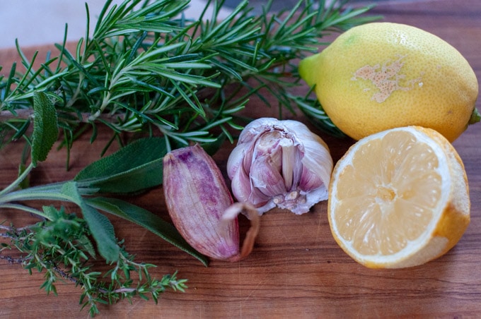 lemon, garlic and herbs on a wooden board