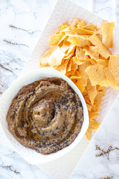 Eggplant dip in a bowl served with socca chips
