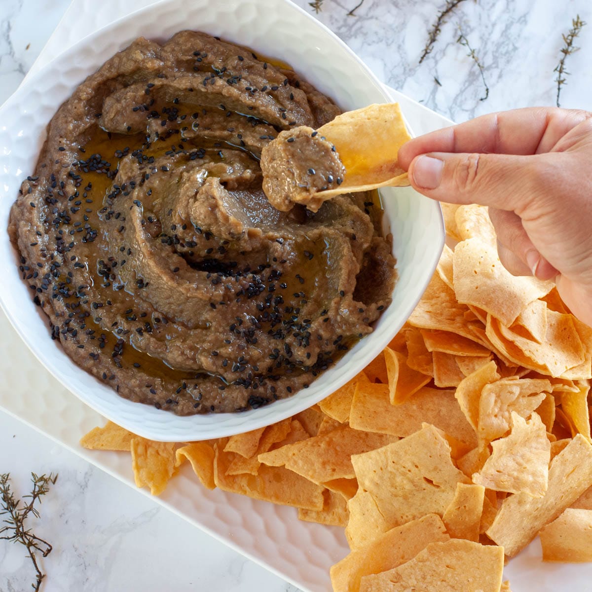 Socca chips dipping into the aubergine caviar