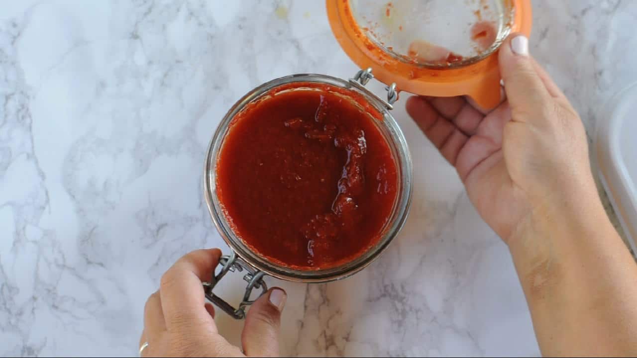 Open jar of homemade tomato sauce