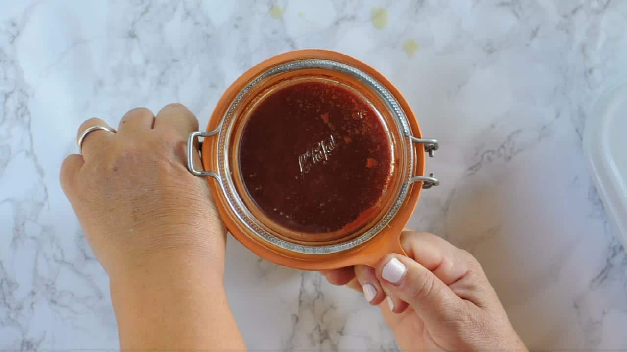 Pull the tongue of the seal of a homemade canned tomato sauce