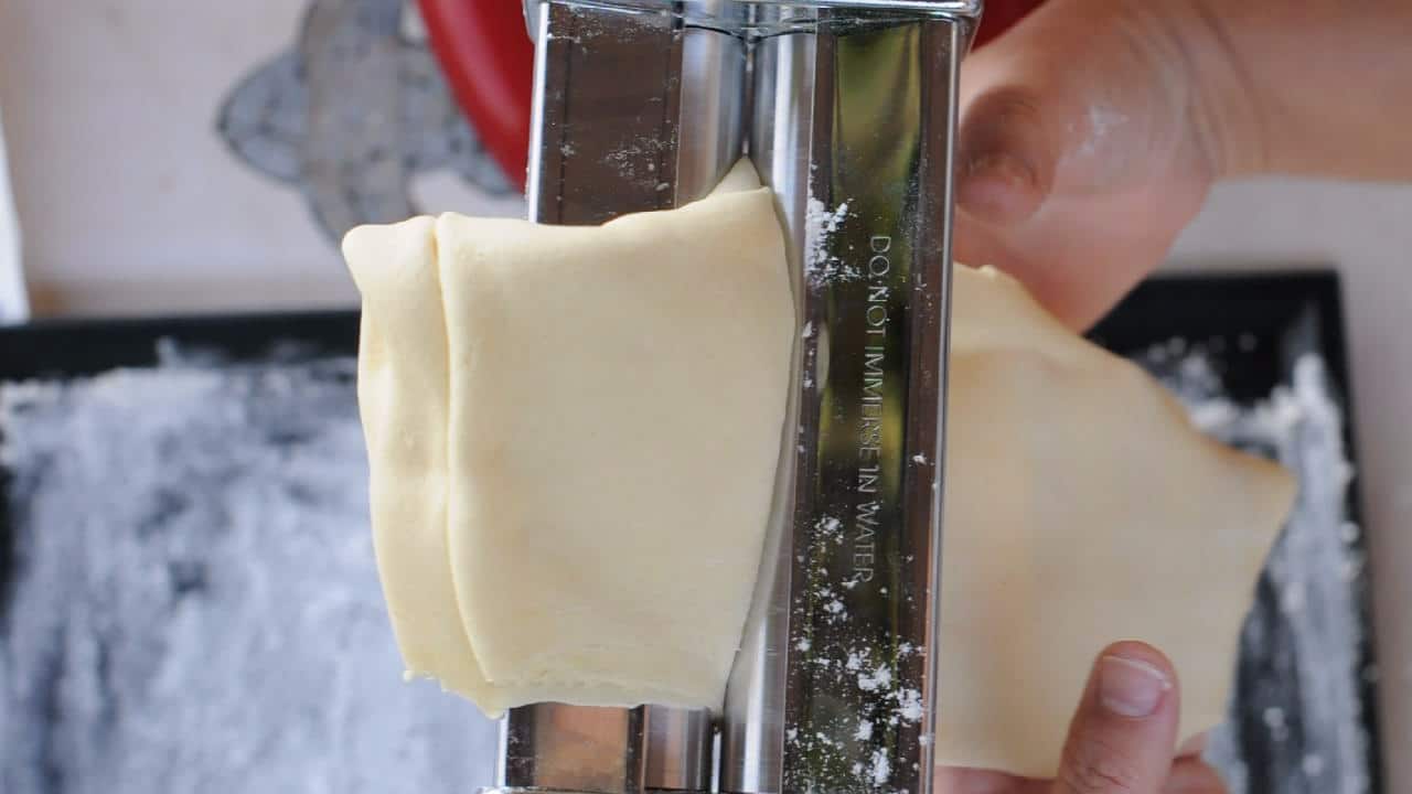 dough rolling through a pasta machine