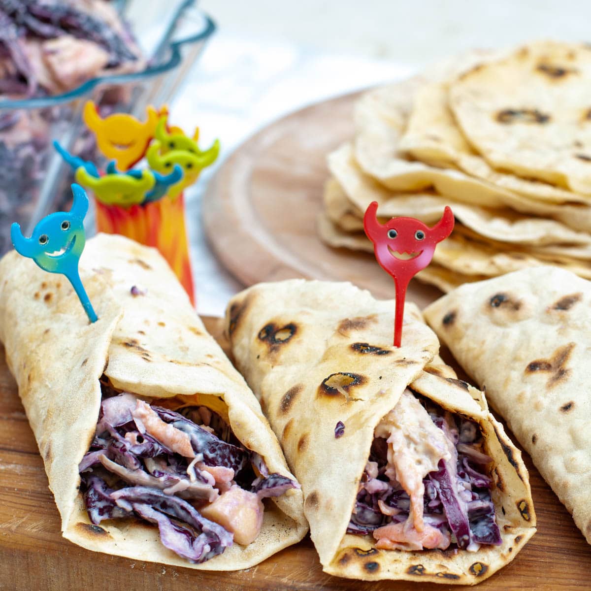 Healthy chicken wraps on a wooden cutting board with some joyful sticks