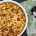 Baked tortellini souffle in the baking dish with a spoon to serve