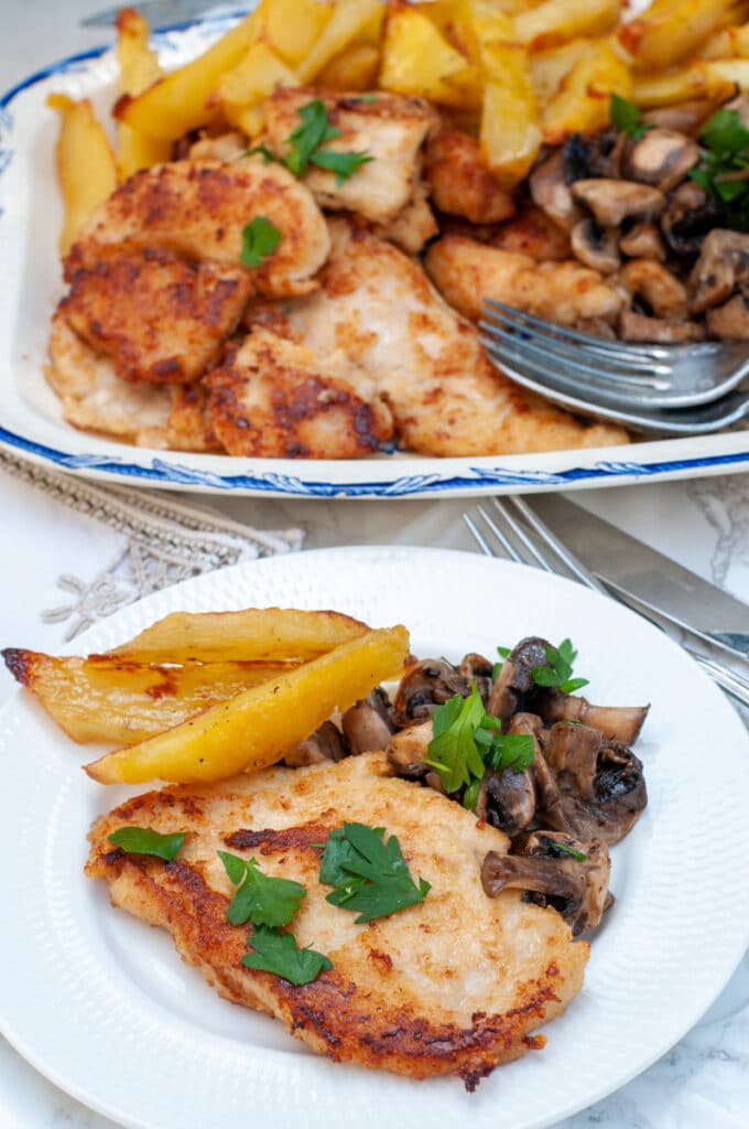 chicken Marsala without cream served on a dinner plate with mushrooms and potatoes