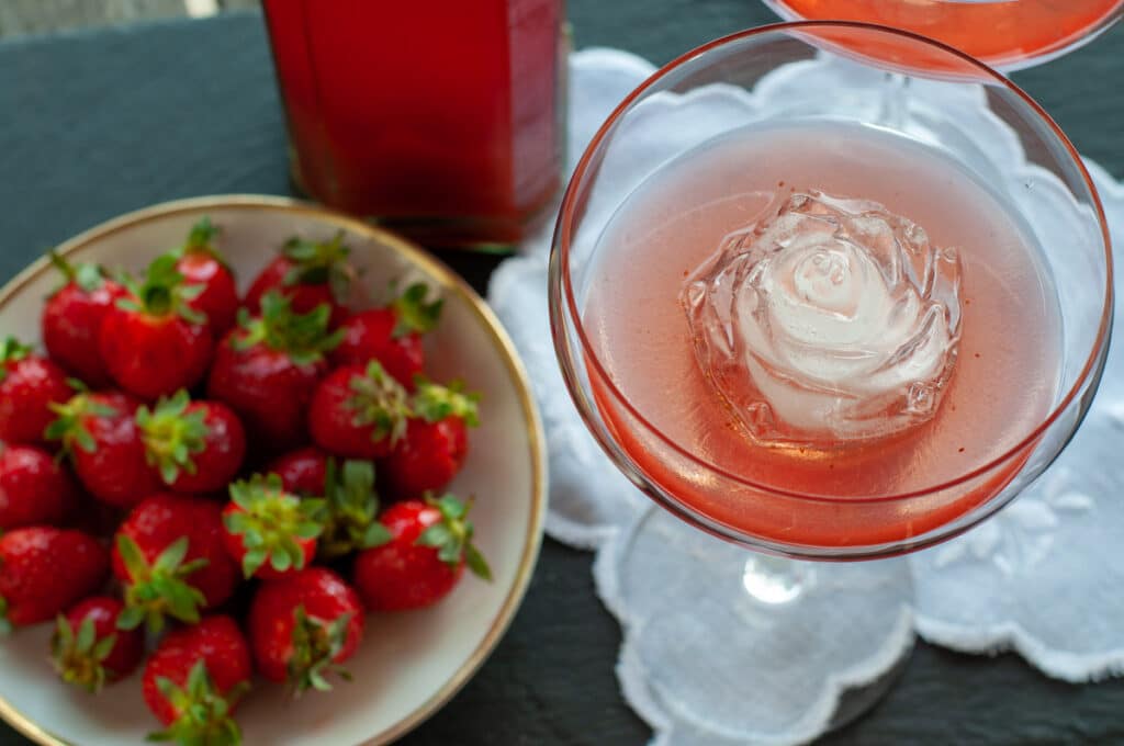 serving the strawberry liqueur with rose ice cubes