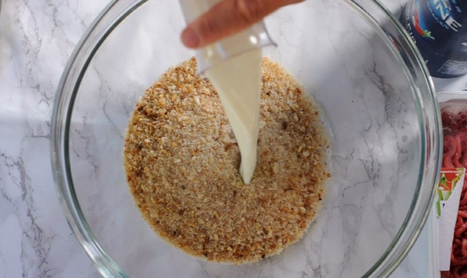 adding milk to breadcrumbs in a bowl