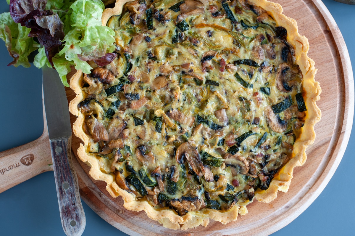 Zucchini mushroom quiche on a cutting board seen from the top