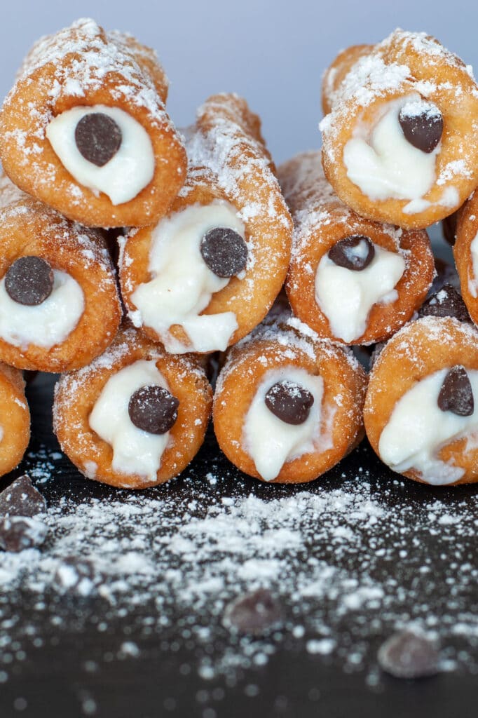 Cannoli piled up on a tray