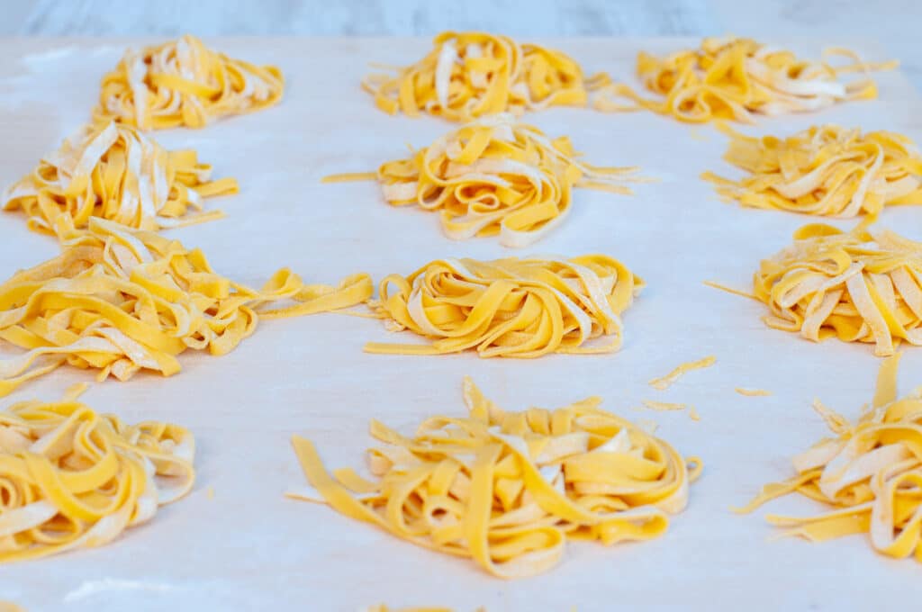 Fresh pasta fettuccine tagliatelle on a floured surface