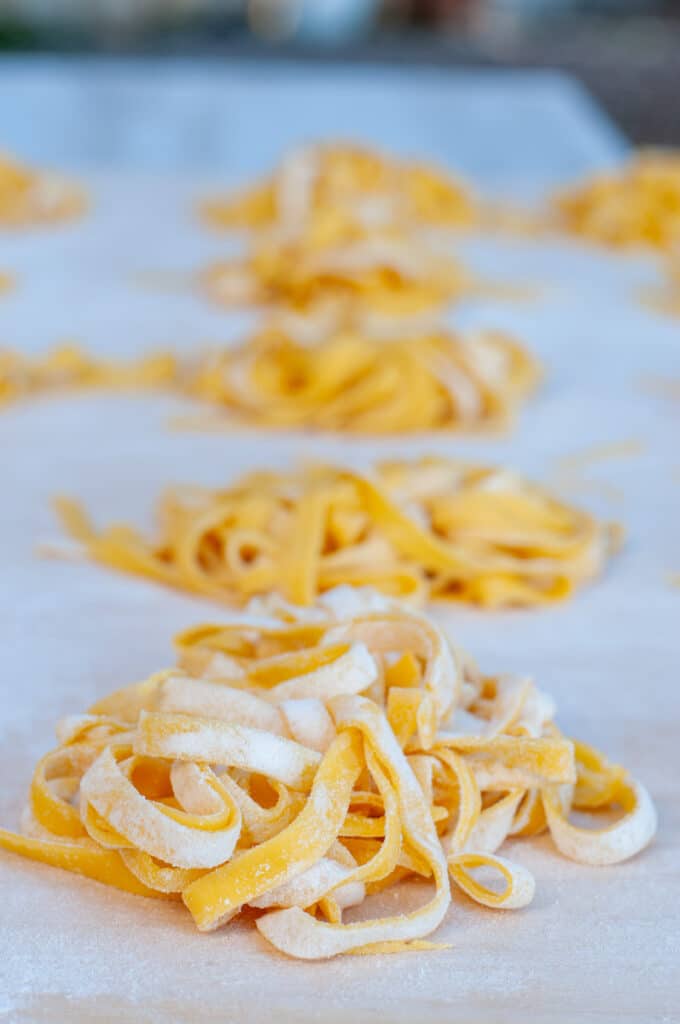 Fresh pasta fettuccine tagliatelle on a floured surface