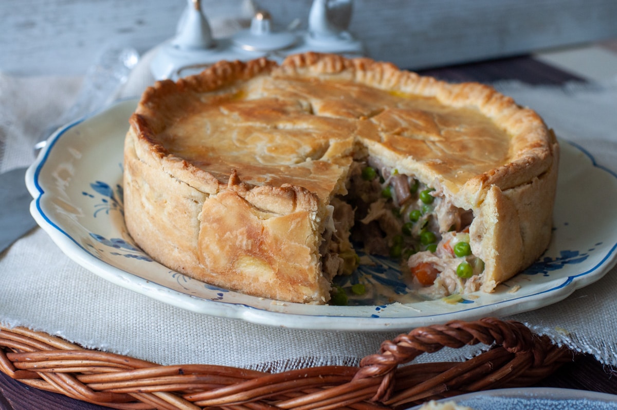 Chicken pie on a plate with a slice open