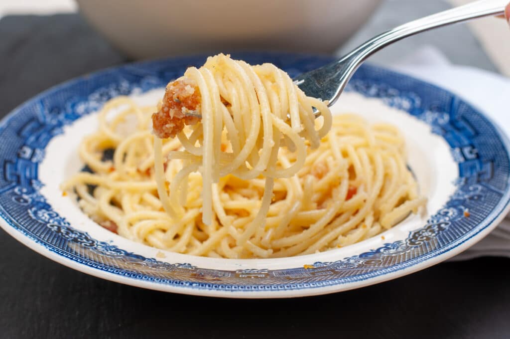 a fork holding spaghetti with bottarga