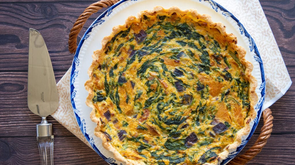 Spinach bacon quiche served on a fancy dinnerware