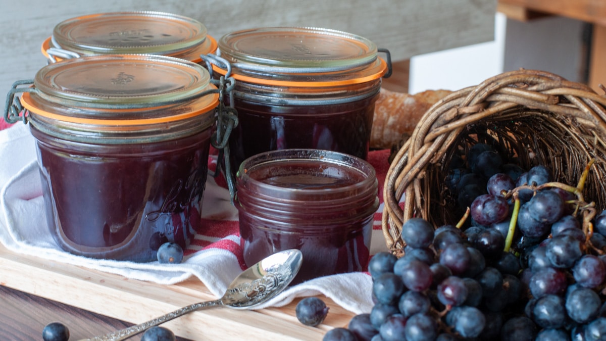 jars of grapes jam next to the grapes