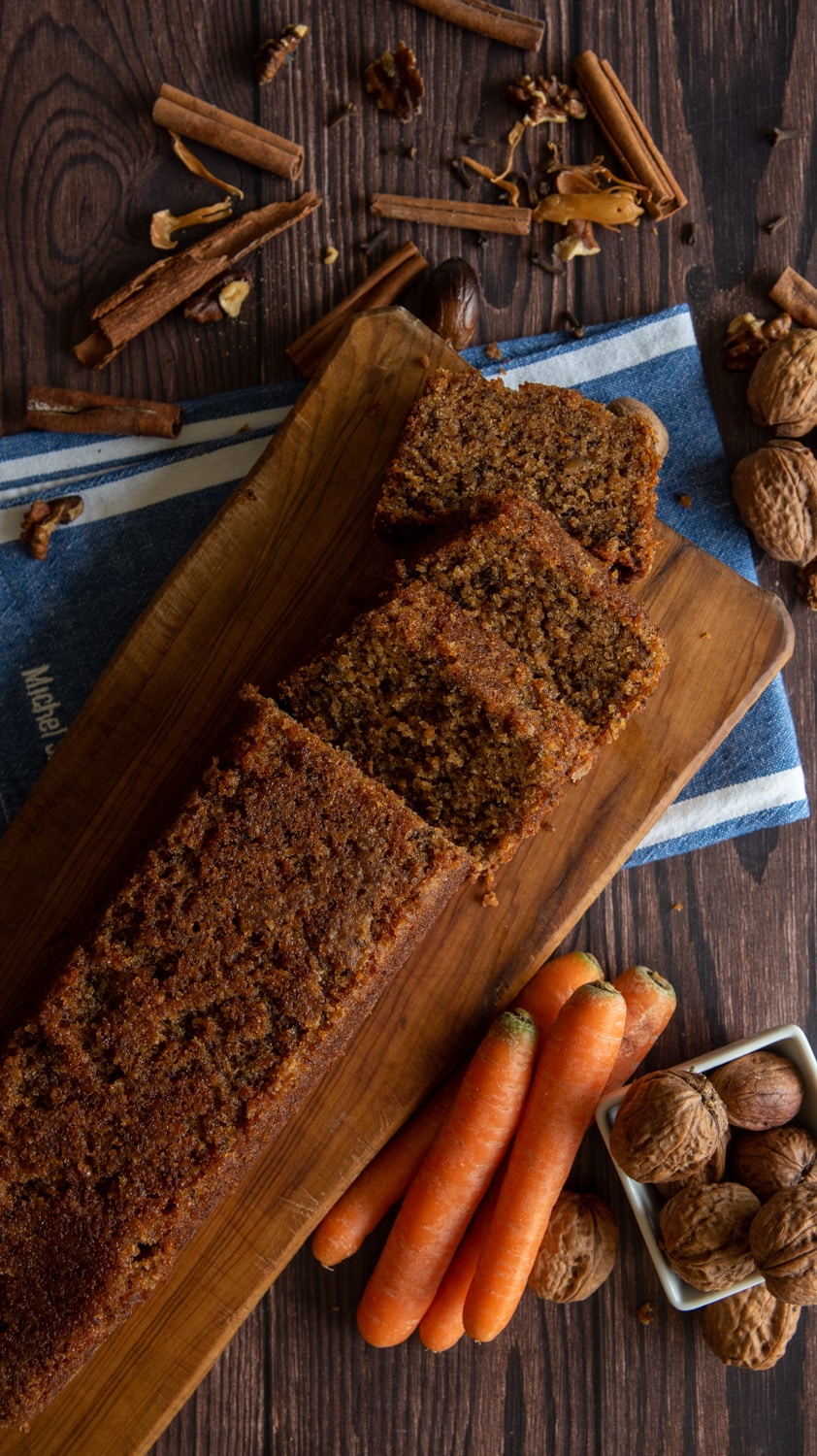Carrot cake loaf on a cutting board cut into slices