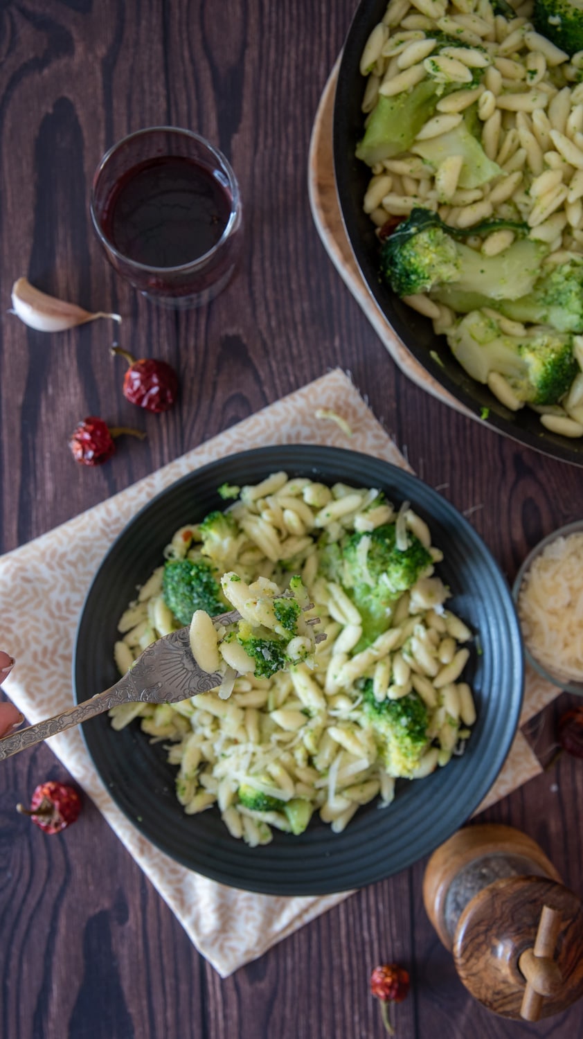 Cavatelli and broccoli served on a dish and a fork lifting a bite