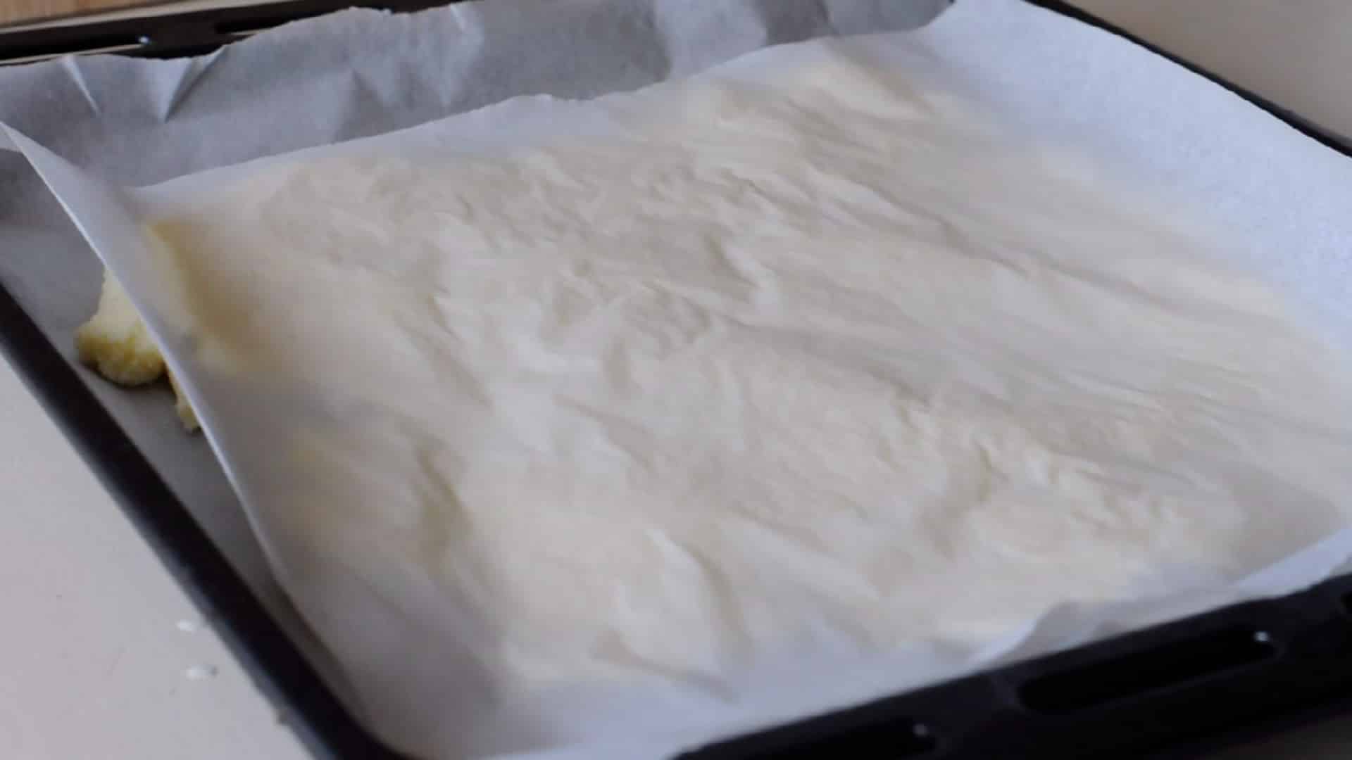Covering it with another sheet of parchment paper