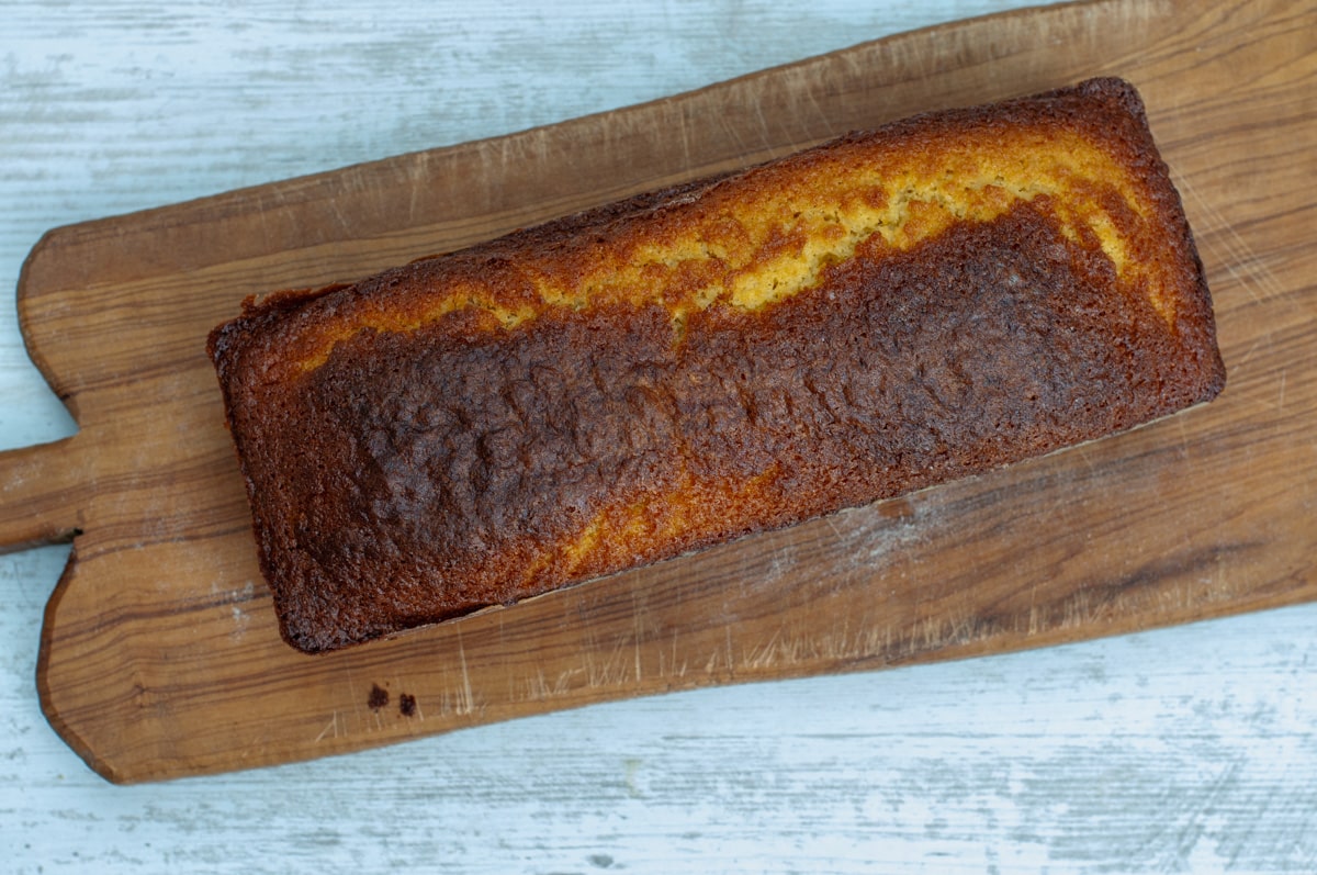 Baked orange cake removed from the pan over a cutting board