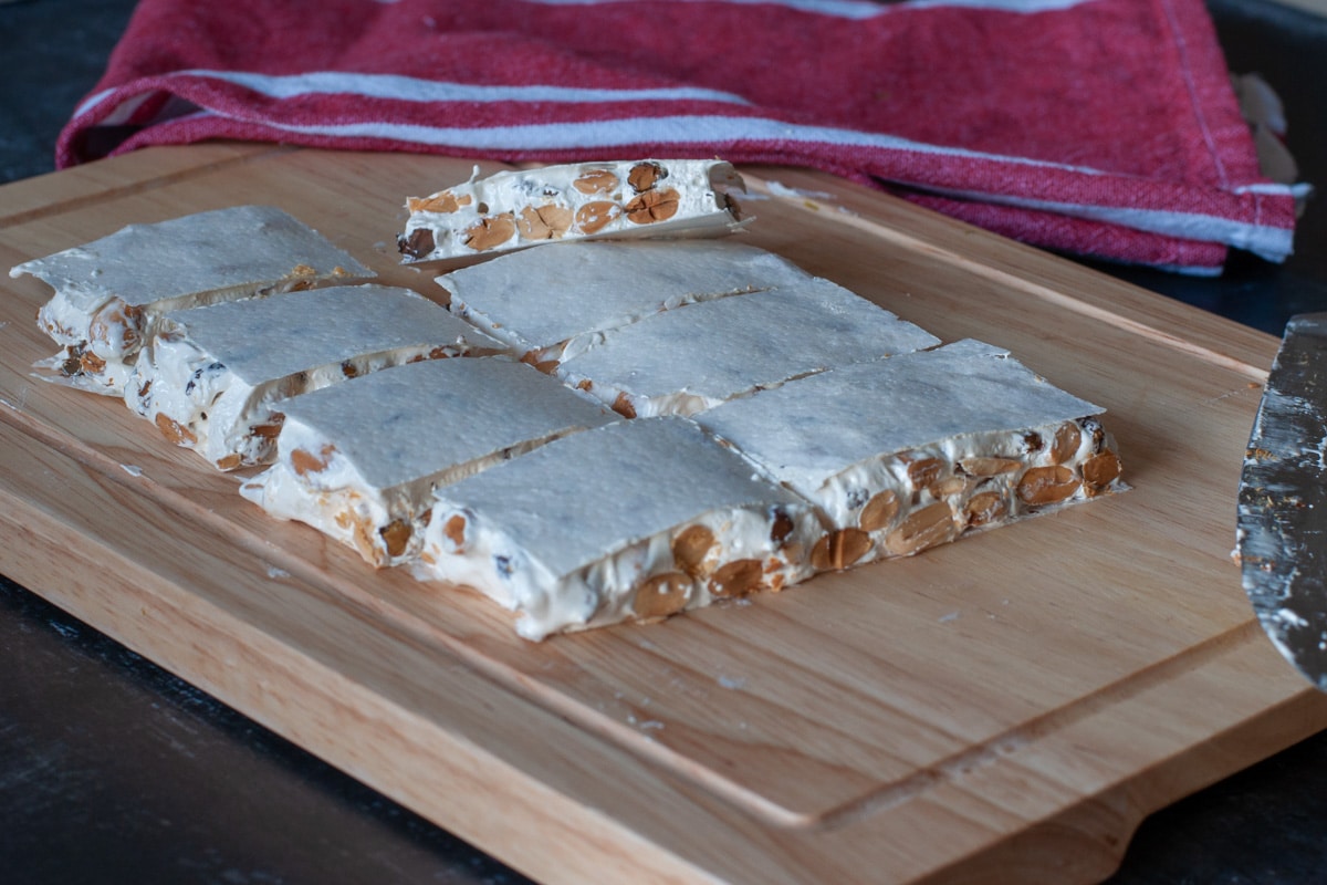 Torrone cut into bars contained by a rice wafer paper