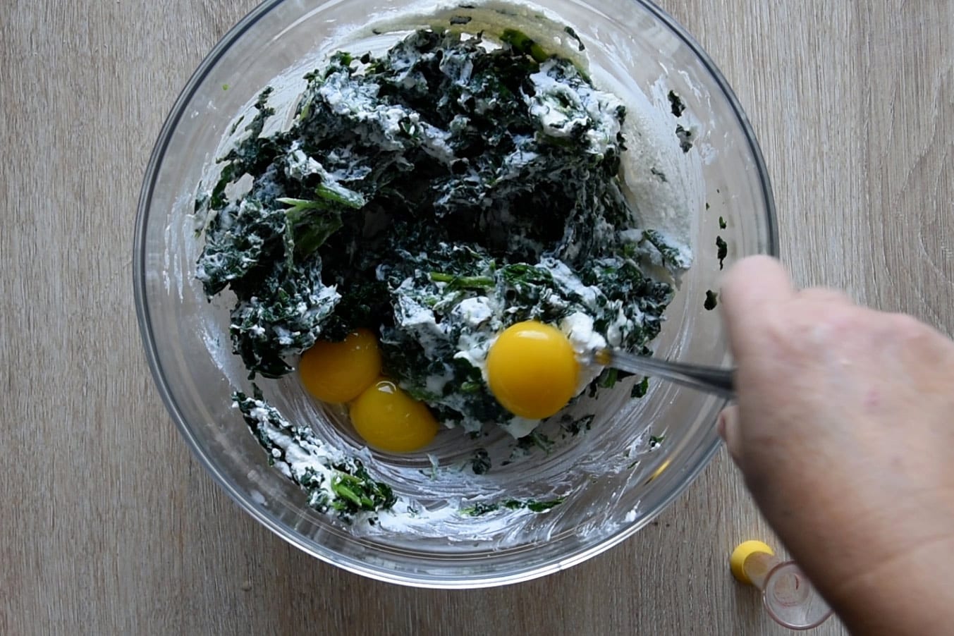 Adding the egg yolks to the spinach and the ricotta