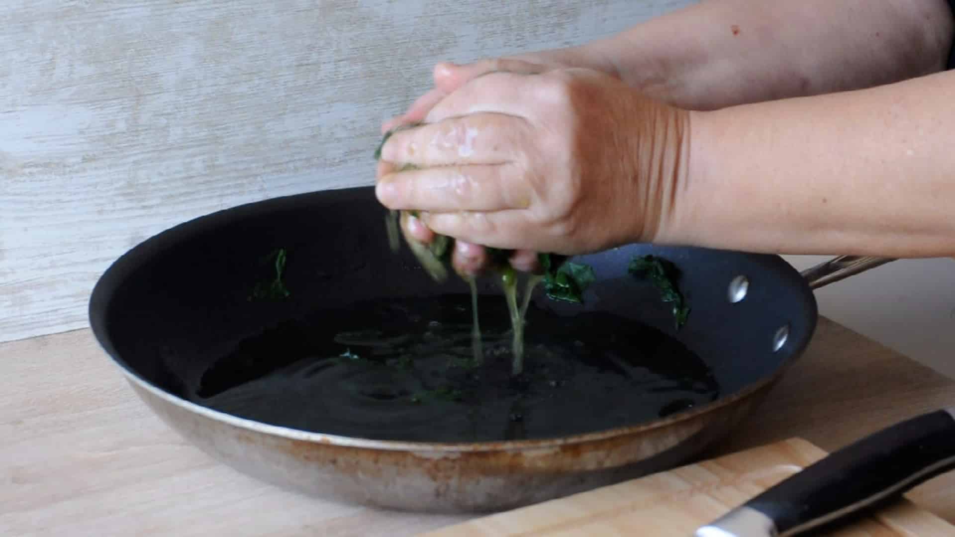 squeezing out the water from the spinach