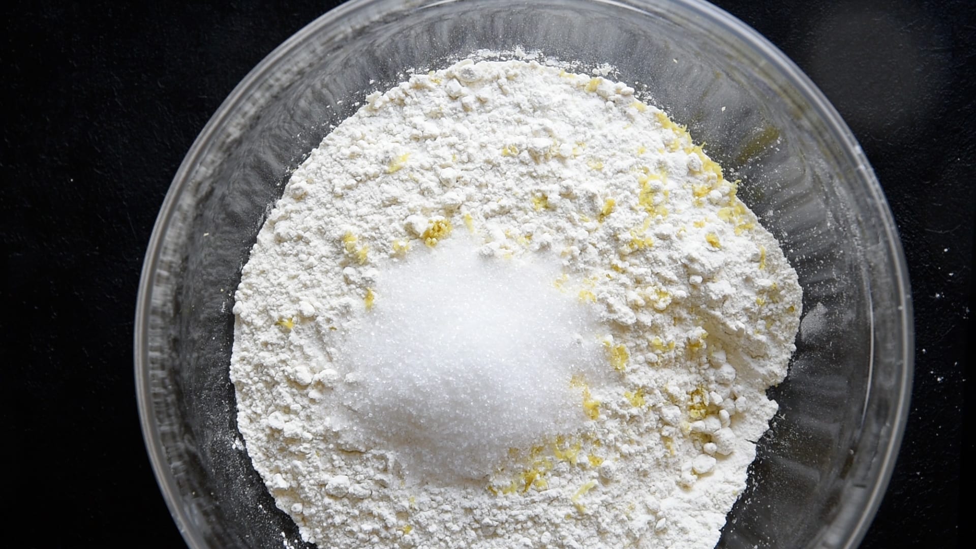 Adding sugar to flour and lemon zest