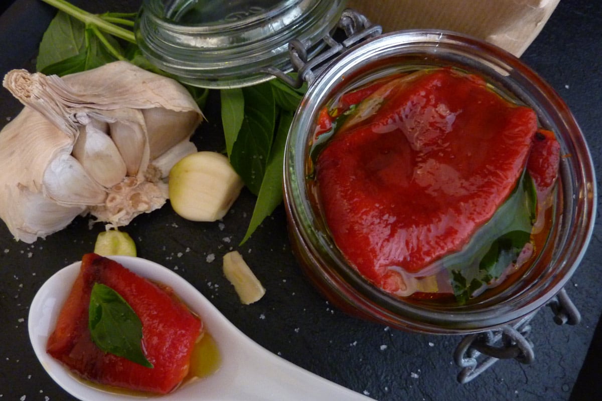 red peppers in a jar with garlic, basil and extra virgin olive oil