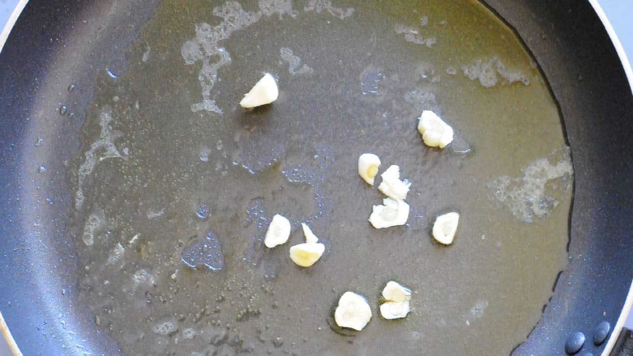 In the same pan where you cooked the fish, stir-fry the garlic cloves