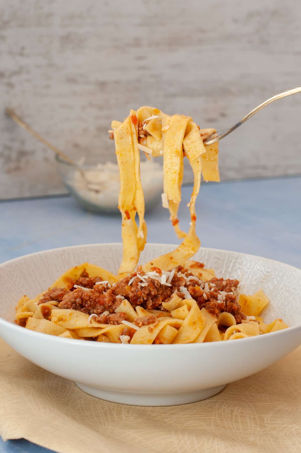 authentich bolognese served with tagliatelle and a fork getting a bite
