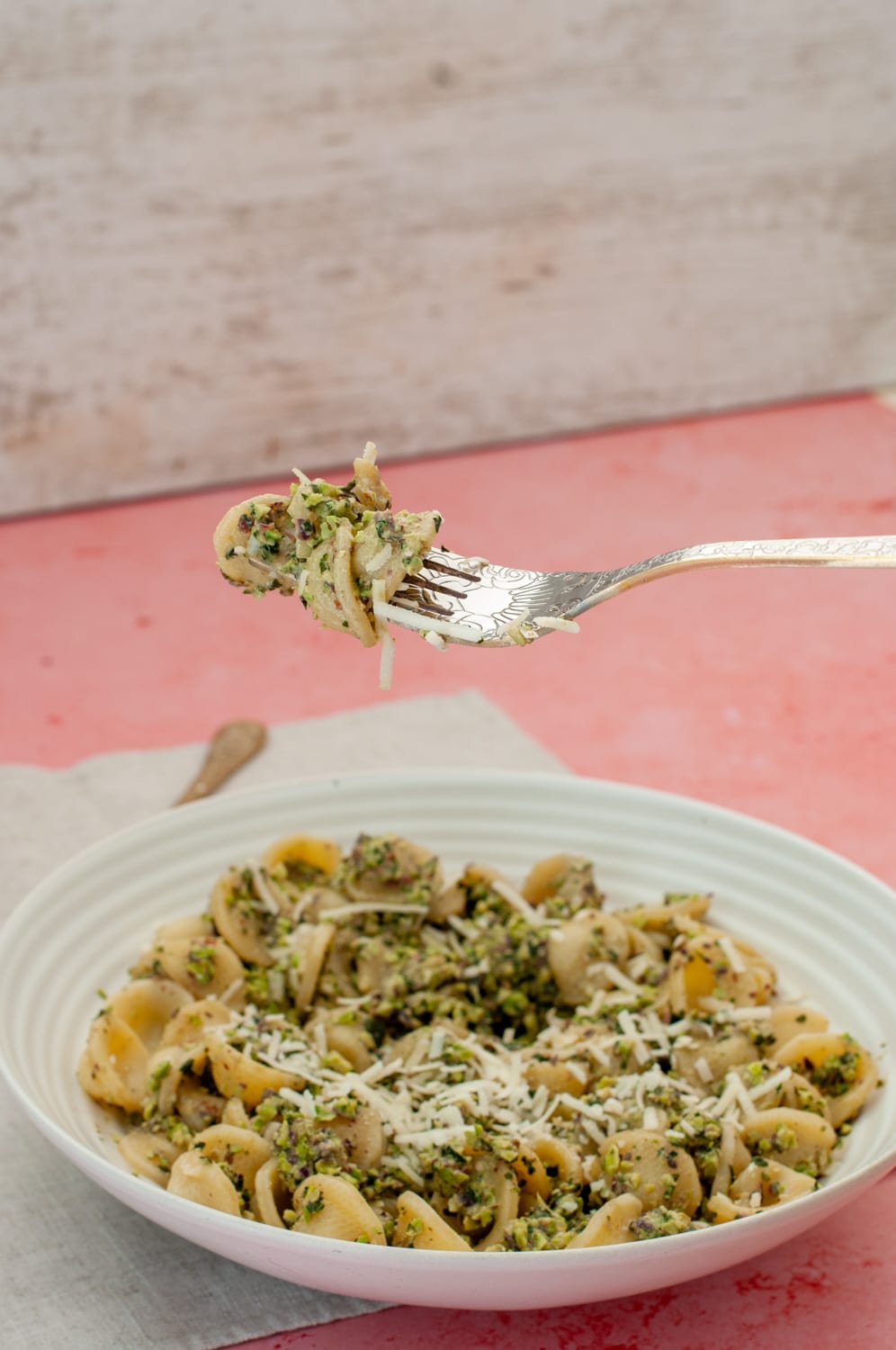 Fork holding pasta with pistachio pesto