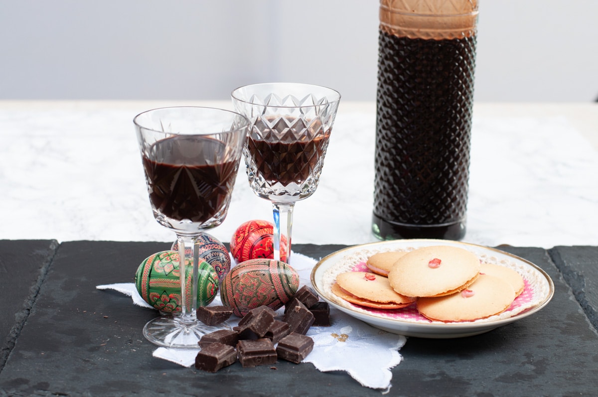 Homemade chocolate liqueur in a vintage bottle poured in two glasses