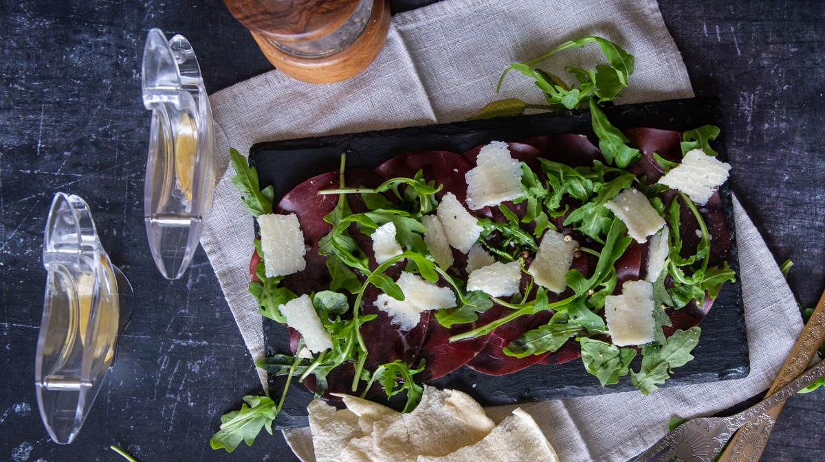 Beef bresaola served with arugula and parmesan cheese
