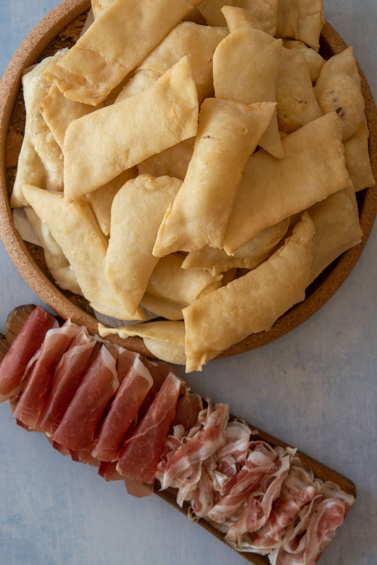 gnocco fritto with culatello and bacon on a cutting board