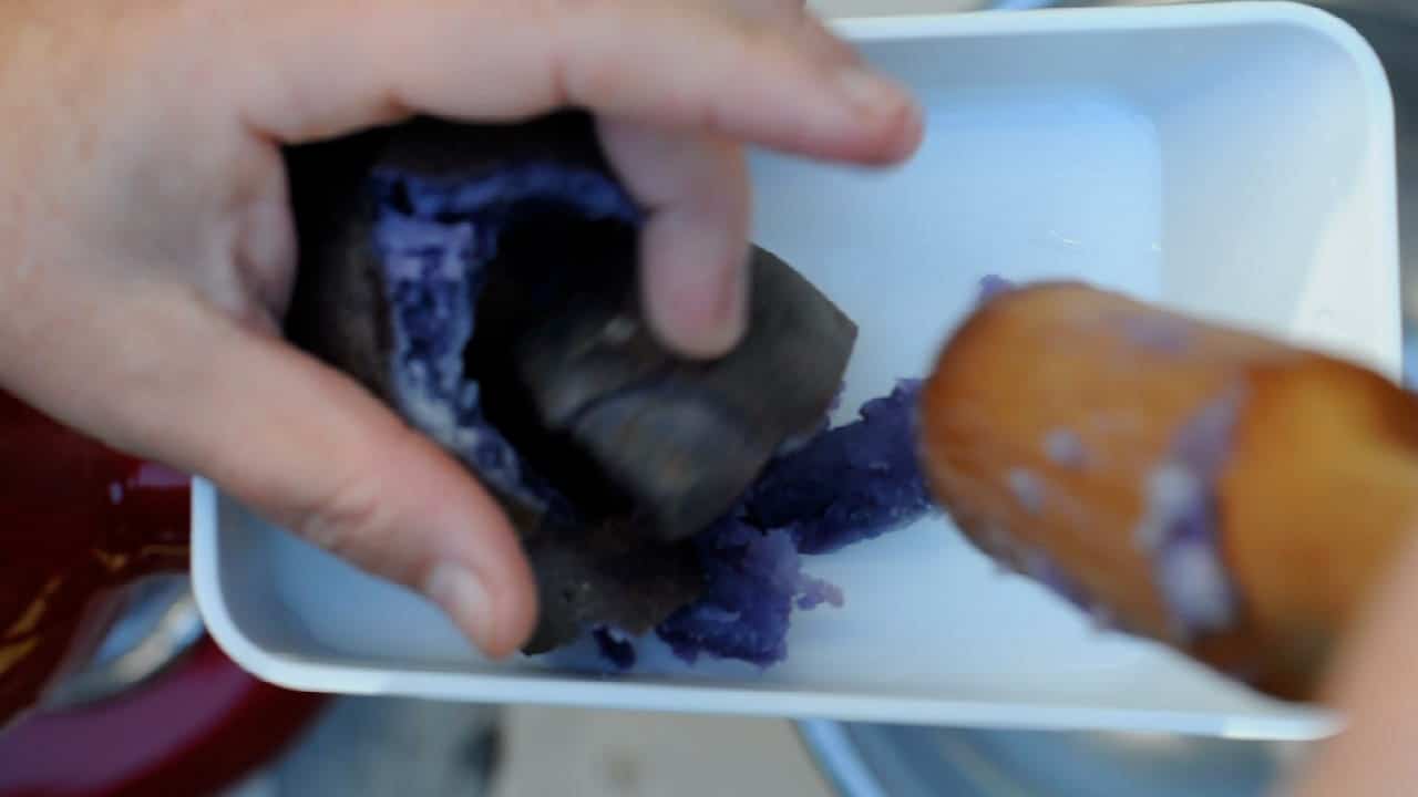 mashing the purple potatoes with the kitchenaid strainer