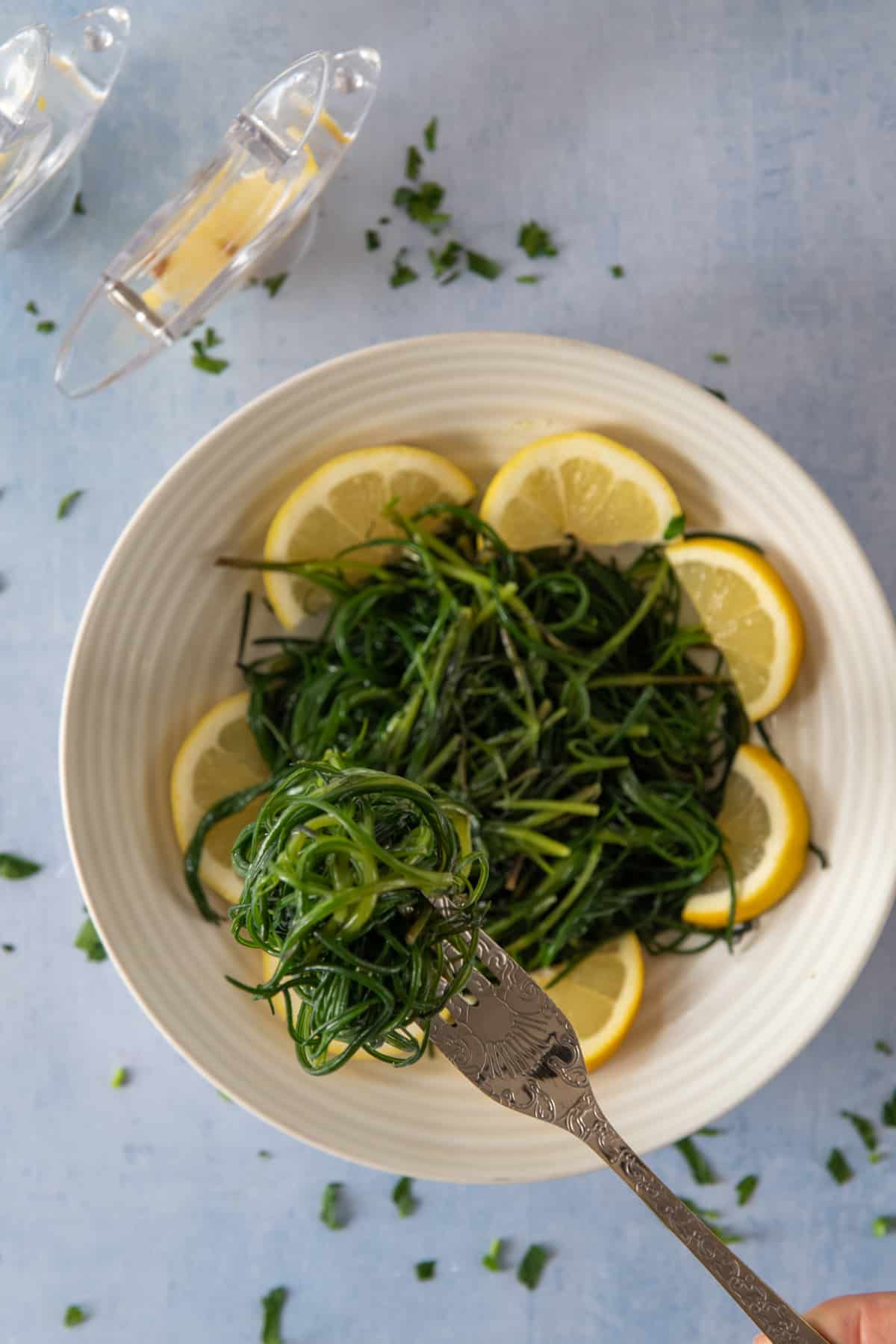 agretti served with olive oil and lemon wedges