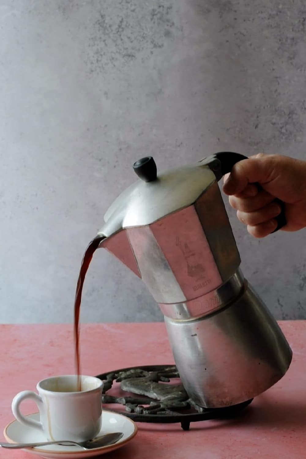 Pouring espresso coffee from a Bialetti moka pot