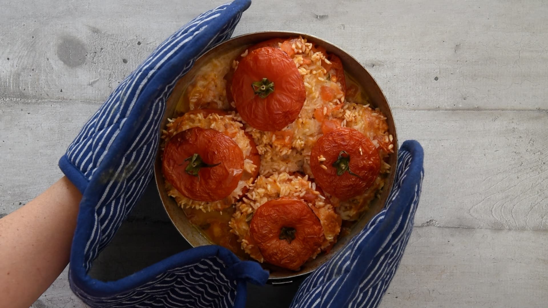 taking the rice stuffed tomatoes out of the oven 