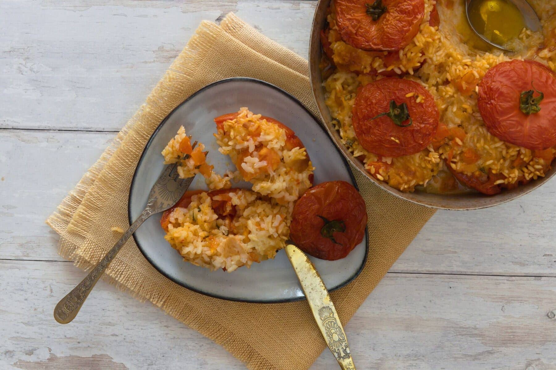 Opened stuffed rice tomatoes to see the creamy inside and the crispy top
