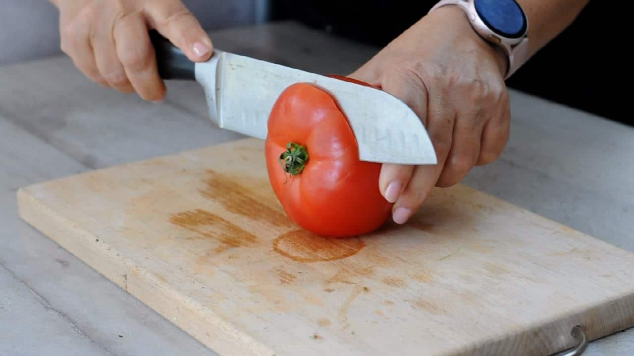 cutting the top of the tomatoes