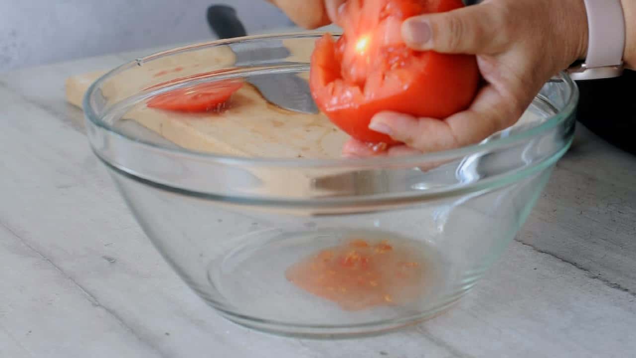 scopping out the pulp of the tomatoes