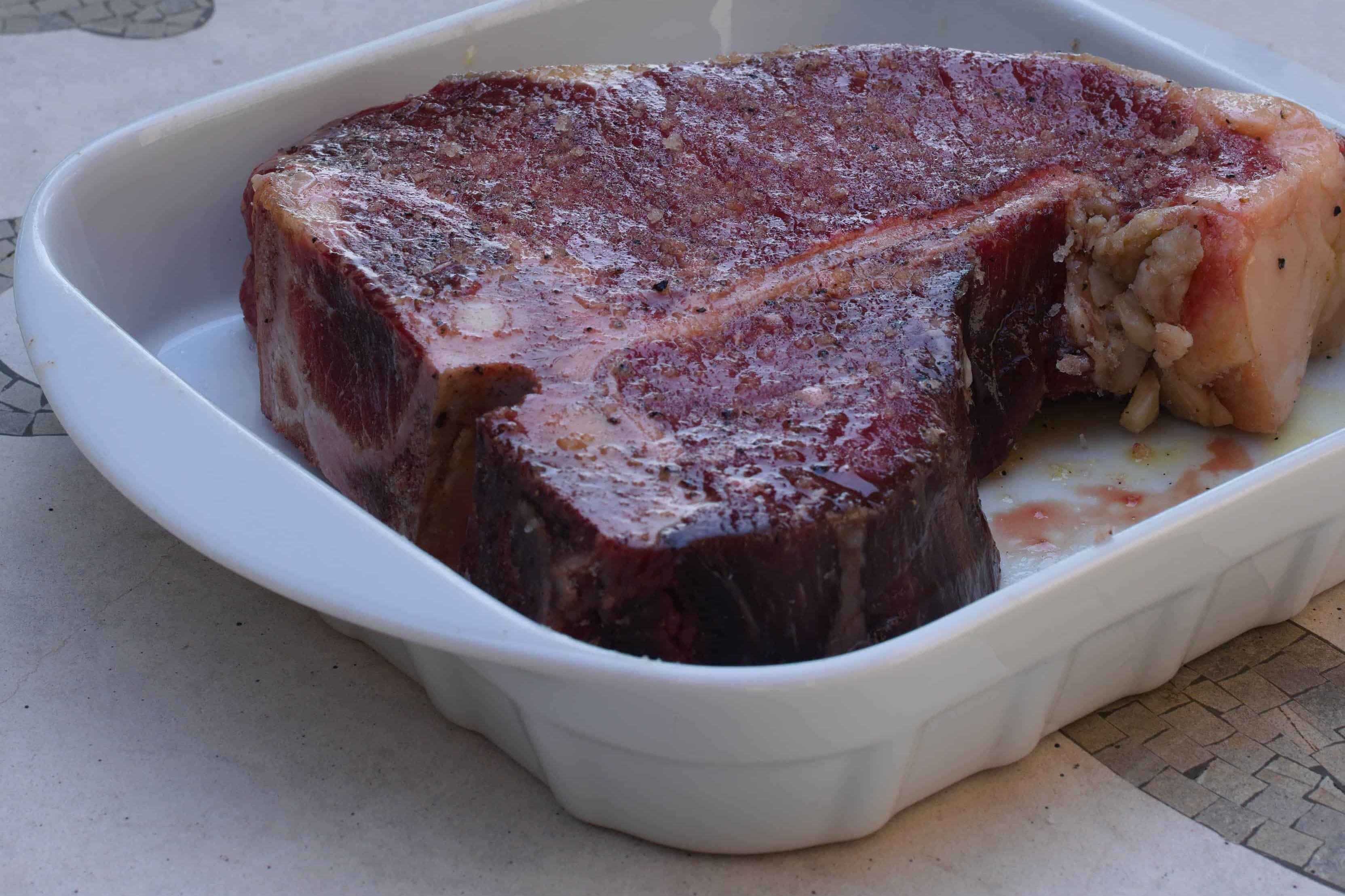 seasoning the steak with salt and pepper