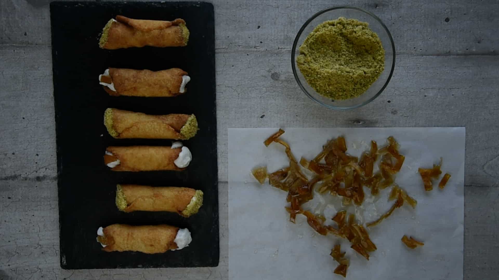 Cannoli decorated with orange peels and pistachio