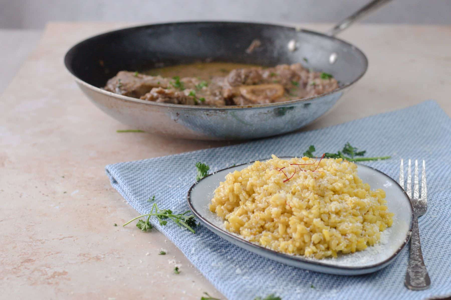 Risotto alla milanese served on a plate and the ossobuchi alla milanese in a pan