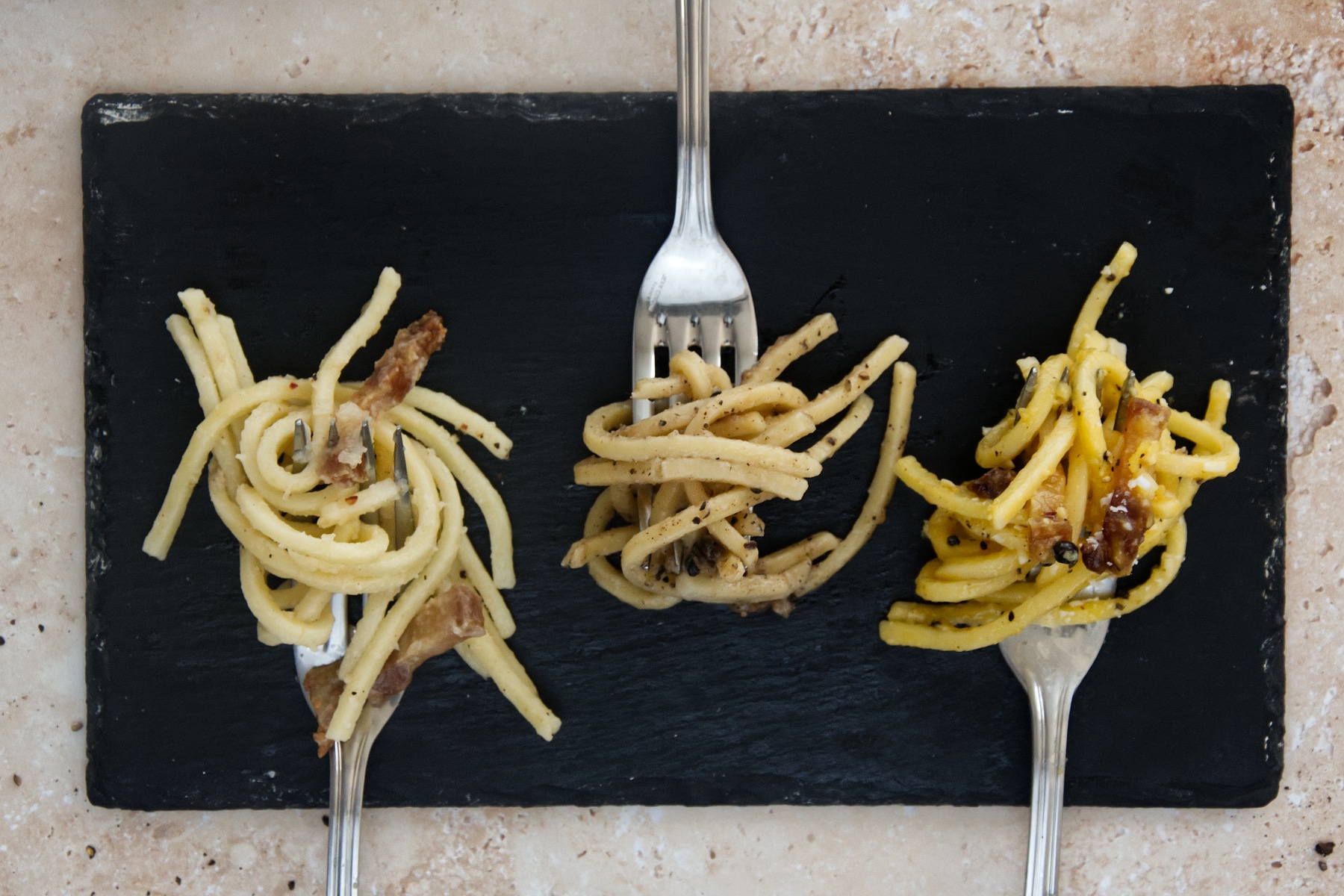3 forks with the 3 roman pasta carbonara, gricia and cacio e pepe