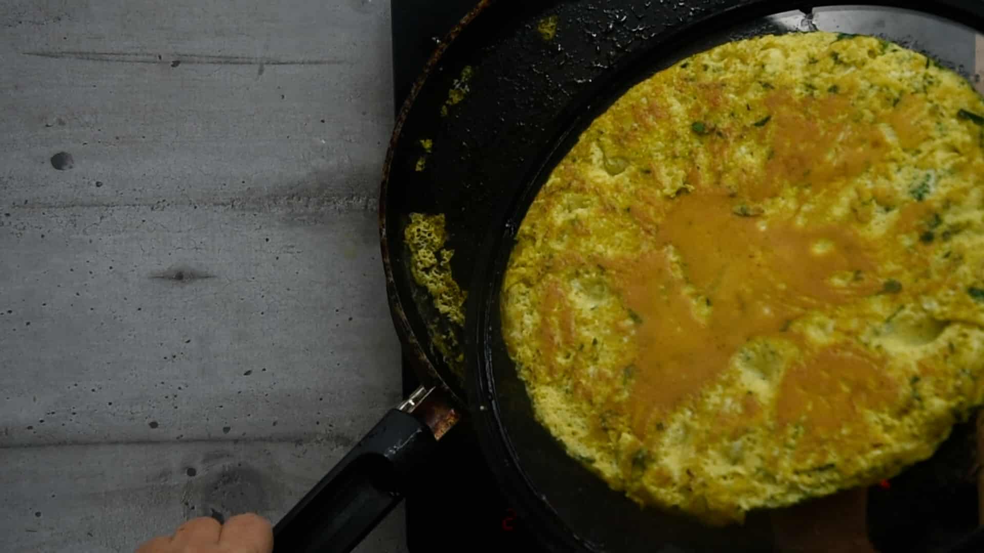 Turn the frittata over with the lid